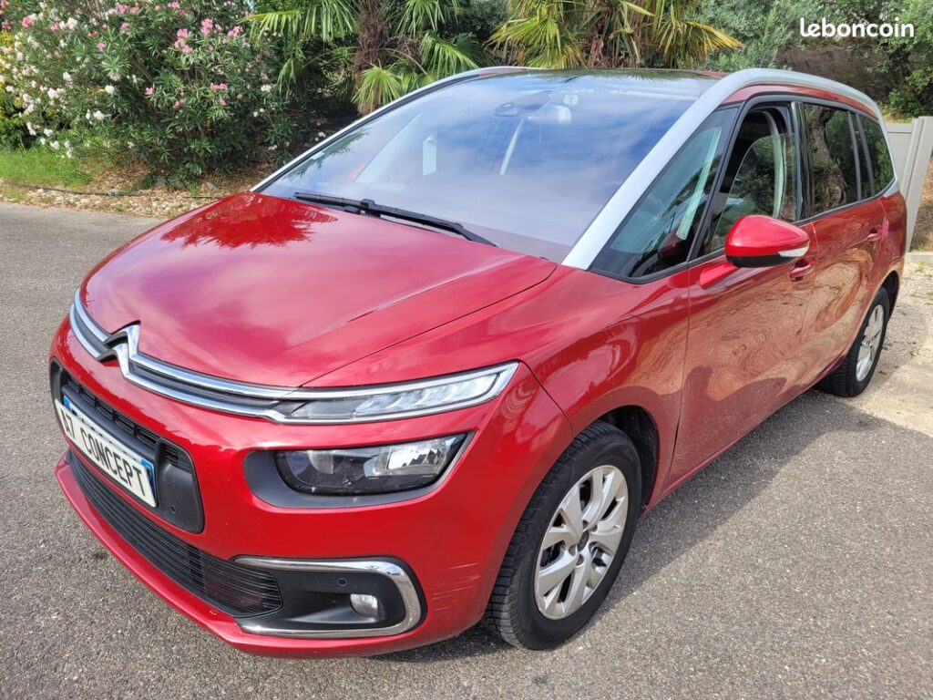 Citroën C4 Picasso rouge d'occasion, monospace. Vue avant. Plaque 'ET CONCEPT'. Rayures sur le pare-chocs.