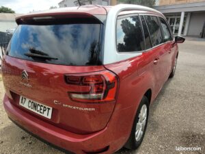 Citroën C4 Spacetourer rouge avec toit blanc, vue arrière trois-quarts. Logos CITROËN et C4 SPACETOURER. Plaque A7 CONCEPT.