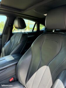 Intérieur voiture luxueux: sièges sport cuir noir, logo M, surpiqûres blanches, toit ouvrant. Vue extérieure. Marque "leboncoin".