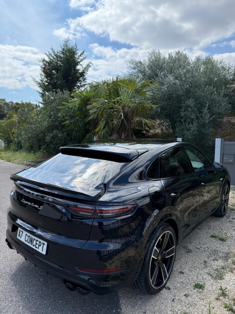 Porsche Cayenne Turbo S coupé noir brillant garé, vue arrière montrant les jantes sport et la plaque 'A7 CONCEPT'.